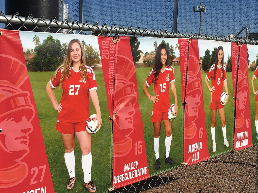 Close-up of a durable, weather-resistant custom sports banner at a soccer field, showcasing intricate team emblems and sponsorship logos, created with our advanced digital printing techniques.